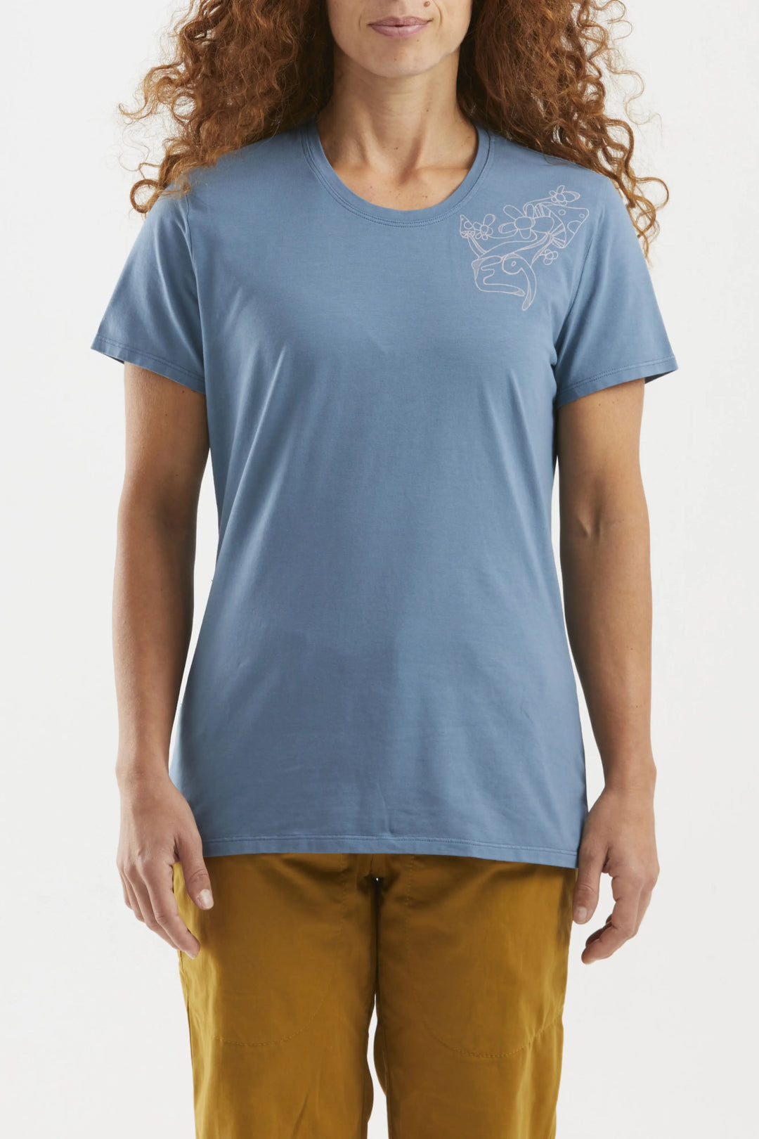 Woman wearing a blue t-shirt with a small design on a plain background