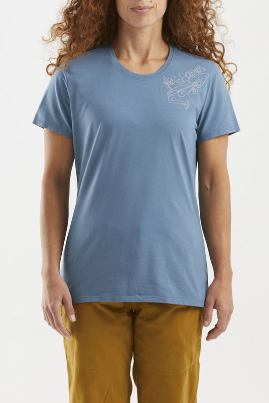 Woman wearing a blue t-shirt with a small design on a plain background