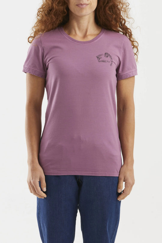 Woman wearing a purple t-shirt with a small logo on a plain background
