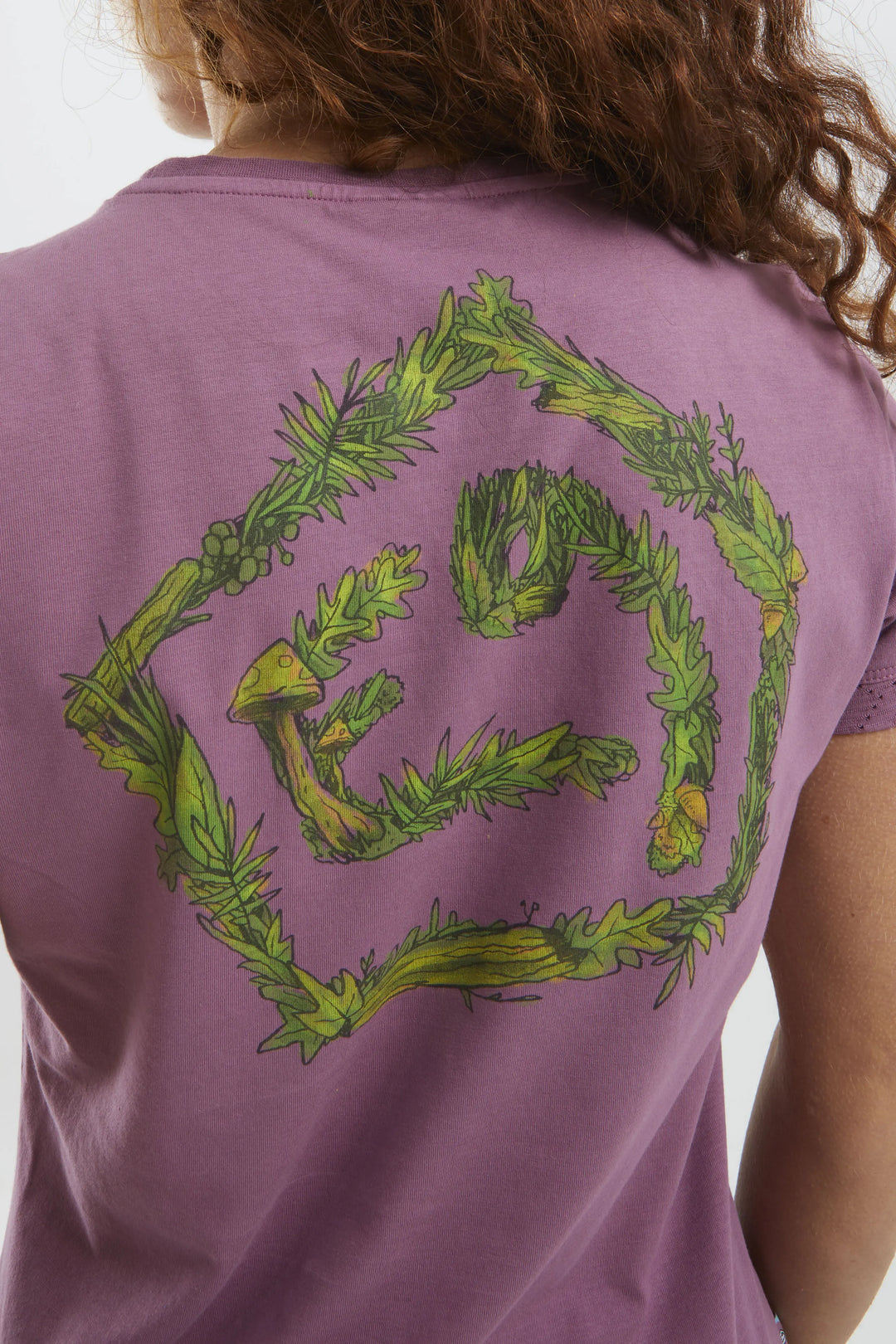 Purple t-shirt with green leafy design on the back, worn by a woman.