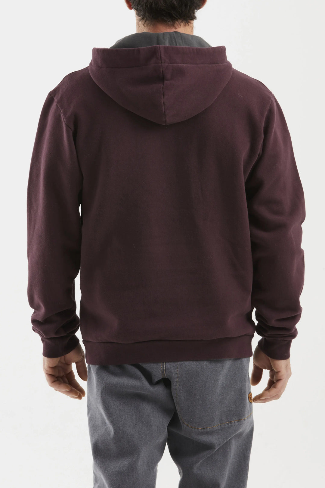 Person wearing a maroon hoodie from behind on a white background