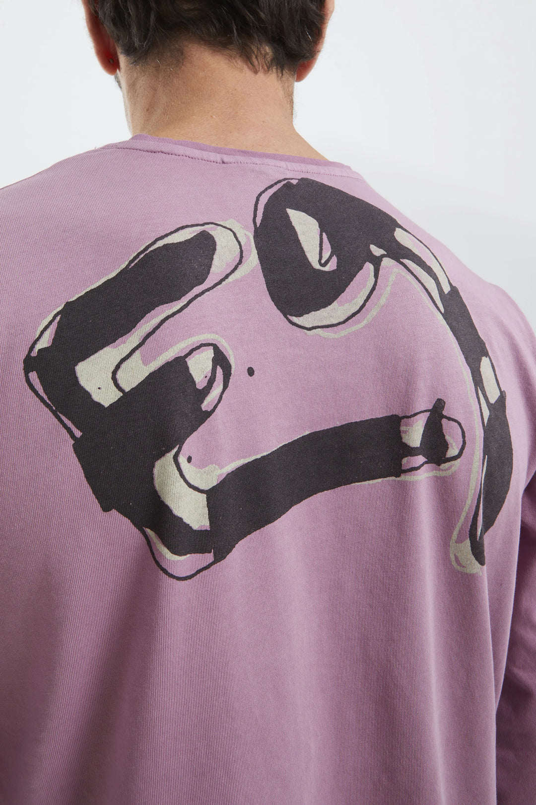 Person wearing a purple sweatshirt with a black graphic design on the back